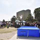 Siamo andati ad assistere al rito, iniziato intorno alle 10.30 del mattino. Quando attraversiamo il varco che porta alla spiaggia li vediamo tutti riuniti nei pressi del bar, sulla distesa erbosa che precede il litorale di sabbia barese